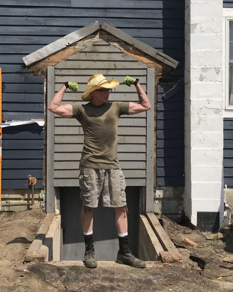 Picture of AWGaluszka posing/flexing in work boots, shorts, tee shirt and cowboy hat.